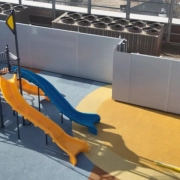 Drone photo of a jungle gym and slide on a Hydrotech commercial roof system installed by Greenwood Industries