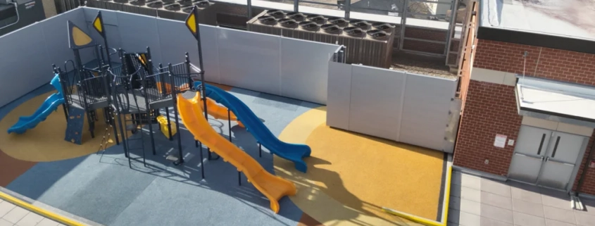 Drone photo of a jungle gym and slide on a Hydrotech commercial roof system installed by Greenwood Industries